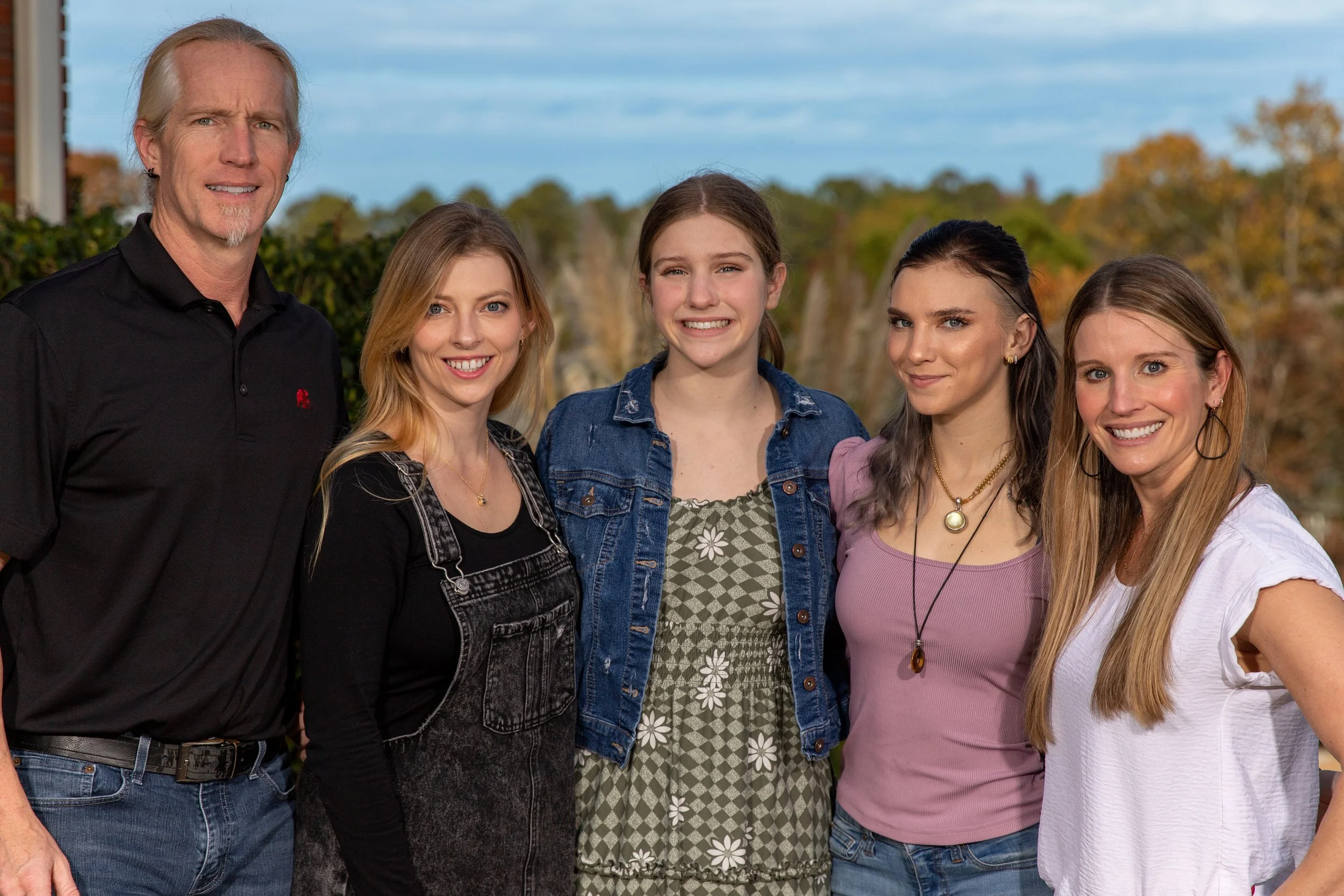 Wes Goode outdoors with his wife and three daughters on an autumn afternoon.